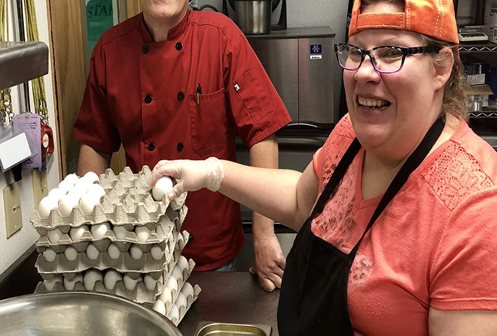 Chef Philip and Liz stand with eggs in the kitchen.